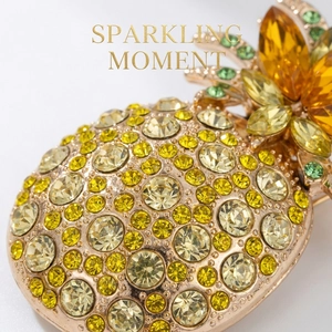 Macro detail of luxury pineapple brooch with yellow rhinestones and green crystals