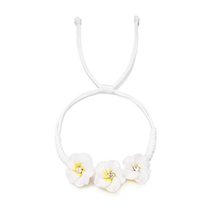Detail eines handgewebten weißen Armbands mit gelben Plumeria-Blüten und eingesetzten Kristallen