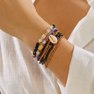 Detailed shot of multi-layer colorful beads bracelet with shell pendant on a wrist