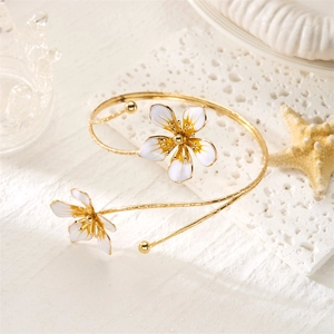 Détail du bracelet jonc doré élégant avec fleurs en émail blanc et centre jaune vif