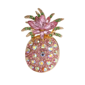 Detailed close-up of a golden pineapple brooch with pink and green faceted crystals