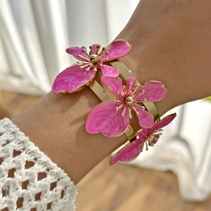 Dettaglio del bracciale a fascia dorato con fiori in smalto rosa in stile tridimensionale