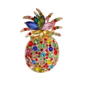 Close-up of vibrant multi-colored rhinestones on a golden pineapple brooch with luxury details