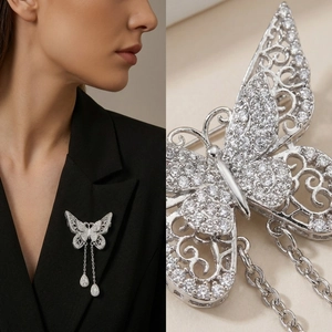 Detailed macro view of hollow butterfly brooch with sparkling stones and long tassels