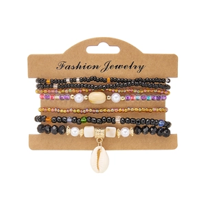 Detail of bohemian multilayer beaded bracelets with shell charm on display card