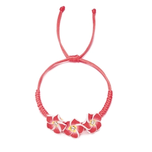 Detail eines roten geflochtenen Armbands mit Frangipani-Blüten und funkelnden Strasssteinen