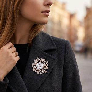 Détail d'une broche flocon de neige avec perles et cristaux sur le revers d'un manteau
