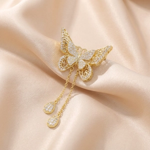 Close-up of gold filigree butterfly brooch with sparkling zircons and fringe tassels