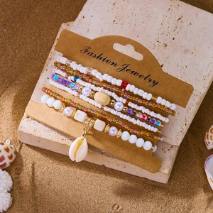 Detail of 7-piece bohemian beaded bracelet set with shell pendant on fashion display card