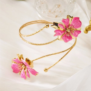 Bracelet de bras spirale doré avec fleurs en émail rose sur fond de soie blanche