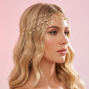 Dettaglio della catena per capelli boho dorata con ciondoli in cristallo e fiori incisi