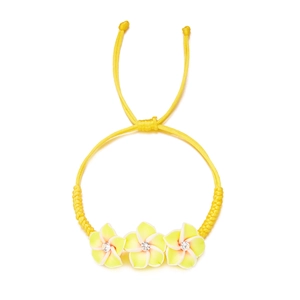 Nahaufnahme des gelben geflochtenen Armbands mit drei Plumeria-Blüten und Strasssteinen