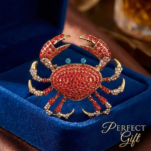 Luxury gold crab brooch with red rhinestones and blue eyes in a velvet jewelry box