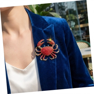 Luxurious red crab brooch with rhinestones worn on a navy velvet suit jacket lapel
