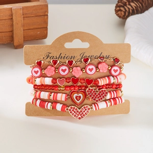 Detail van een gelaagde rode hartjes kralen armband set met klei kralen en bedels