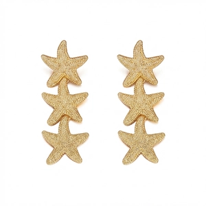 Close-up of triple gold starfish dangle earrings with detailed textured metal finish
