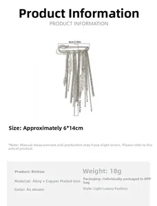 Detail view of fashion brooch pin with metal tassels and clear stone on white background