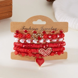 Detail van rode hartvormige kralenarmbandset met gouden bedels op kraftkaart