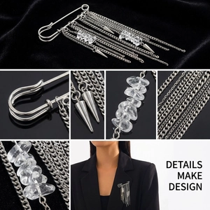 Detailed view of silver chain tassel brooch with white crystal and metallic spikes