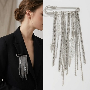 Detail of punk tassel brooch with silver pins and chains on black blazer lapel