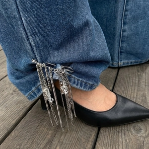 Silver fringe tassel safety pin brooch with multi-layer chains on denim pants