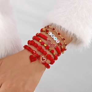 Detail van rode kralenarmbandset met LOVE-belettering en hartjesbedels voor dames