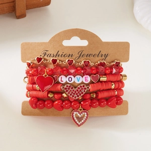 Detail van vijf rode kralenarmbanden met hartjes en LOVE-bedeltjes op een kaart