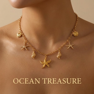 Close-up of gold starfish and seashell charms on a delicate chain necklace on model
