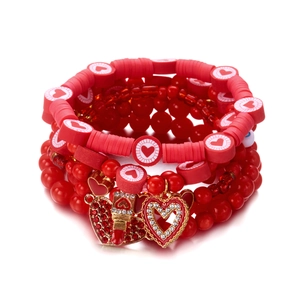 Detail van rode hartkralen en lippenstiftbedeltjes op een meerlaagse kralenarmbandset