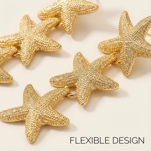 Detailed macro view of flexible starfish dangling earrings in matte gold finish texture