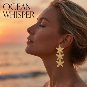 Detailed view of long gold starfish earrings with textured finish worn on the beach