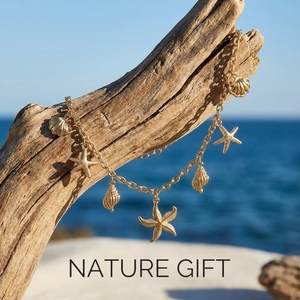 Golden starfish and seashell charms on a beach-themed chain against ocean backdrop