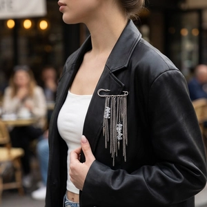 Silver punk pin brooch with chain tassels and crystal beads on a black leather jacket