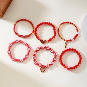 Detail van de 6-delige rode hartjes armbandset met kleikralen en I U bedeltjes