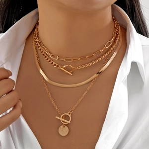 Elegant multi-layer gold necklace set with OT buckle and coin pendant on a white shirt