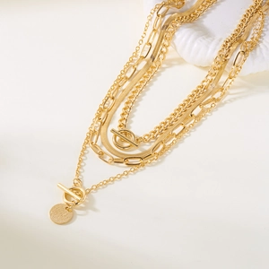 Gold multi-layer coin pendant necklace featuring snake chain and toggle clasp