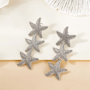 Detailed view of silver starfish drop earrings with shimmering textured surfaces
