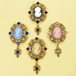 Vintage cameo brooches with ornate gold frames, rhinestone accents and drop pendants
