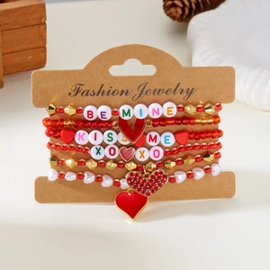 Detail van rode hartvormige kralenarmbanden met bedeltjes op een sieradenkaart