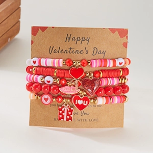 Handgemaakte gelaagde kralenarmbandset met hartjes voor Valentijnsdag op een kaart