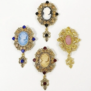 Vintage Baroque cameo brooches set with metal filigree frames and dangling crystal pendants