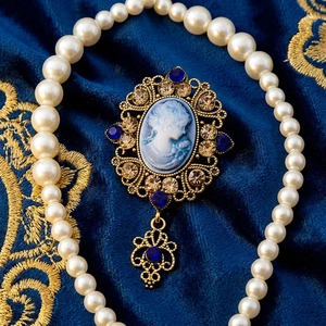 Close-up of vintage relief brooch with blue gemstone and gold filigree on velvet