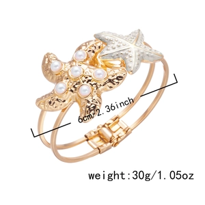 Detail view of gold starfish bracelet with white pearls and 6cm inner diameter size