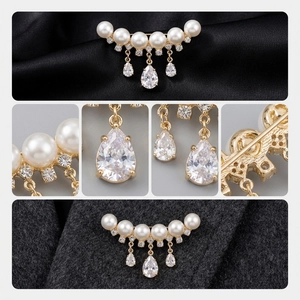 Detail of elegant pearl brooch with teardrop gems and zircon dangles on a grey coat
