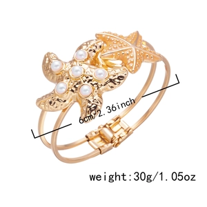 Detail view of starfish bangle showing 6cm inner diameter and 30g weight on white background