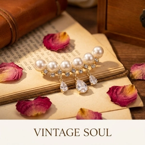 Detailed macro view of pearl tassel brooch with rhinestones on a vintage book page