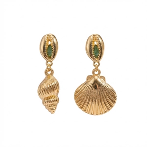 Detalle de pendientes de concha dorados con piedras verdes y dijes de estilo náutico