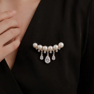 Elegant gold curved brooch with white pearls and sparkling crystal waterdrop tassels