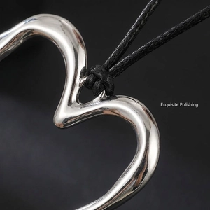 Macro shot of polished silver heart pendant with black cord necklace detail