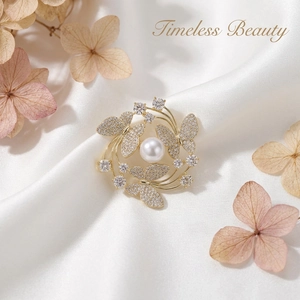 Macro shot of three golden butterflies with pavé crystals surrounding a white pearl